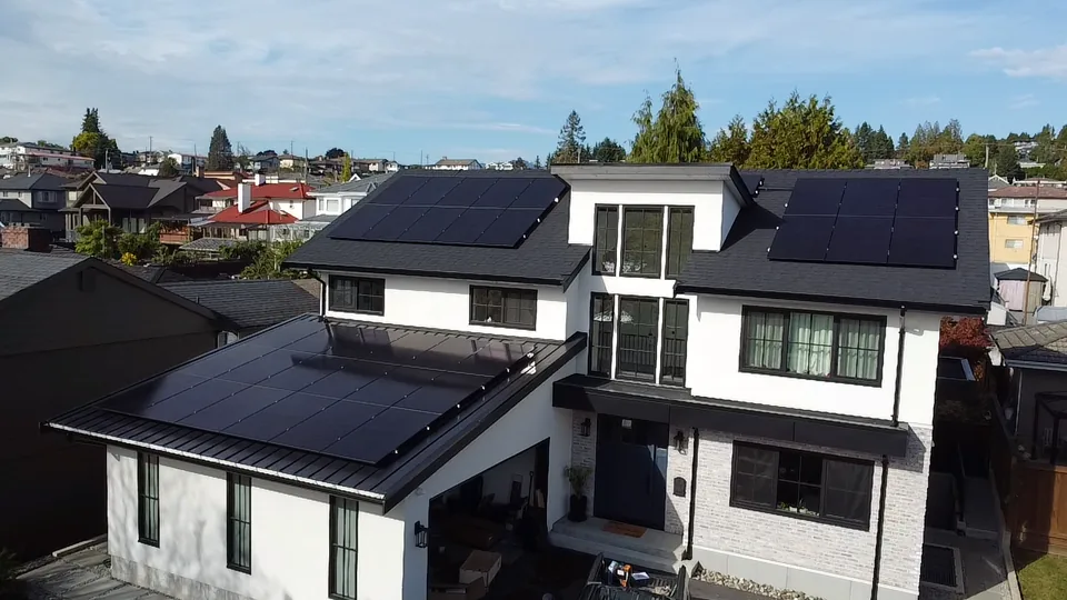 Aerial view of black solar panels across the roof planes of the Twin Lions home in North Vancouver