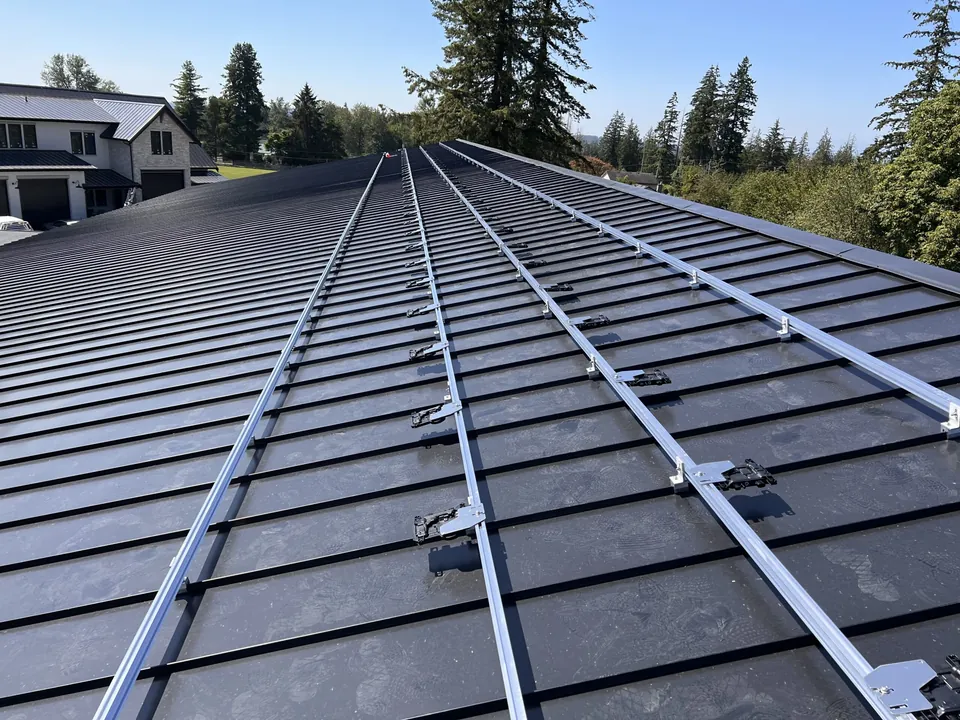 Solar racking rails fastened across a standing seam metal roof before the panels go on